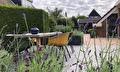 Complete tuin met terrassen, zwarte douglas schutting en veel groen 